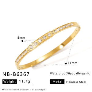 Detail view of gold-plated stainless steel bangle with inlaid white cubic zirconia crystals