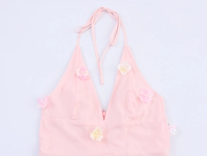 Détail d'un haut licou rose avec appliqués de fleurs 3D et centres de perles