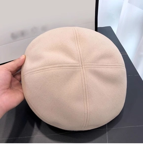 Dettaglio della cucitura a croce e della lana beige sulla parte superiore del berretto