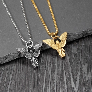 Macro view of vintage gold and silver angel pendants on slate and wood background