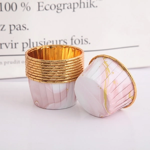 Detail of pink marble pattern paper cake cups with elegant gold rolled edges
