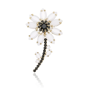 Elegant rhinestone daisy brooch with white petals and gold trim on white background