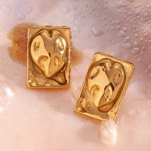Macro detail of 18K gold-plated irregular rectangular earrings with abstract heart texture