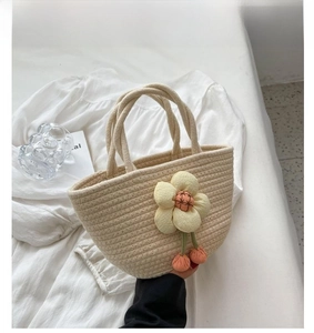 Detail of cream woven tote bag with 3D sunflower accent and decorative tassels