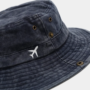 Washed cotton bucket hat with small airplane embroidery and bronze ventilation eyelets