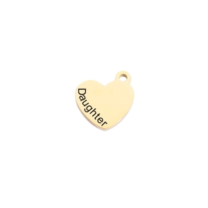 Macro shot of gold heart pendant with Daughter engraving and metal ring attachment