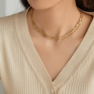Minimalist double-layered 18K gold plated titanium steel necklace worn on a V-neck shirt