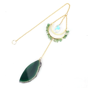 Detail of green agate slice and crystal moon suncatcher with golden chains