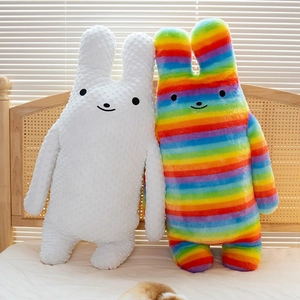 Cartoon long-eared rabbit plush pillows in white minky dot and rainbow faux fur on a bed