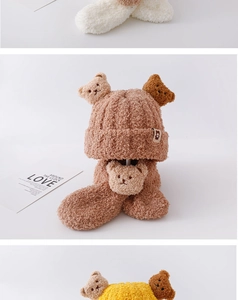 Detailed view of plush knit baby hat and scarf set with cute bear decorations