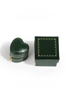 Detail of dark green jewelry boxes with gold patterns and smooth satin lining