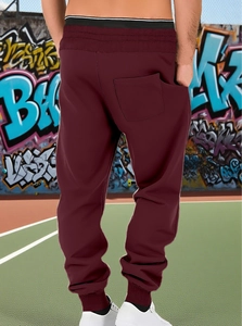 Detail of burgundy joggers showing the elastic waistband and rear pocket on the back