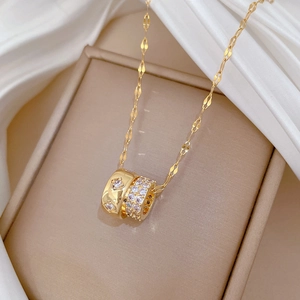 Macro view of gold titanium steel double ring pendant with sparkling crystals on silk