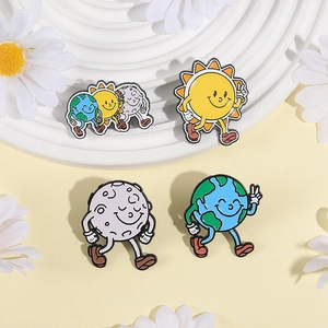 Cartoon enamel pins featuring sun, moon, and earth designs on a white tiered display