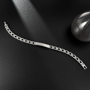 Polished silver stainless steel link bracelet with rectangular plate on black background