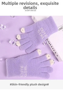 Detail of purple plush gloves featuring white Cute Girl text and soft knit texture