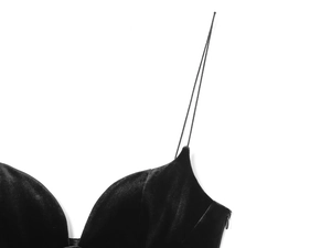 Detail of black velvet bodysuit featuring delicate shoulder straps and soft fabric texture