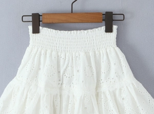 Détail de la taille élastique haute et broderie florale blanche sur une jupe en coton