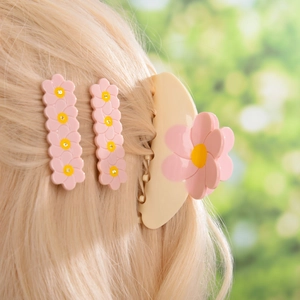 Barrettes fleurs roses et pince à cheveux crème ornée de strass sur les cheveux