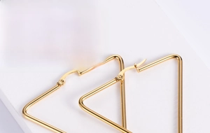 Detailed view of minimalist gold triangle hoop earrings with a secure clasp closure