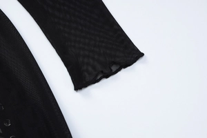 Detail of sheer black mesh dress featuring wavy edge cuffs and star flocked pattern