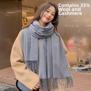 Detail showing 35% wool and cashmere blend fabric with soft long fringe on grey scarf