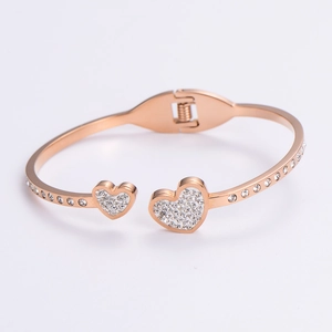 Detail of rose gold double heart bangle with pavé zircon settings and a side hinge clasp
