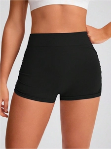 Detail of high-waisted seamless ribbed knit yoga shorts in black with a peach lift effect