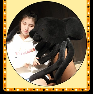 Large black spider plush toy held by a model to show its realistic size and soft material