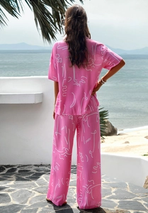 Detail of light pink summer set showing white abstract print and fluid fabric texture