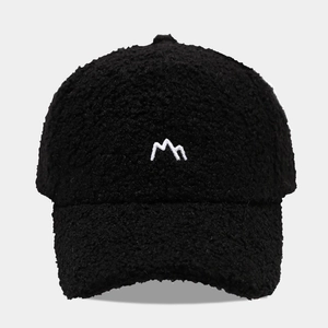 Close-up of black fleece baseball cap featuring white mountain peak embroidery texture