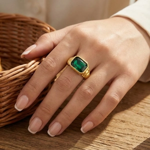 Macro detail of French vintage twisted gold ring with rectangular emerald gemstone