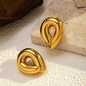 Detailed macro view of 18K gold plated stainless steel teardrop earrings on stone