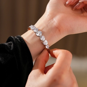 Vue détaillée d'un bracelet de cœur en argent avec pierres de zircone portées au poignet