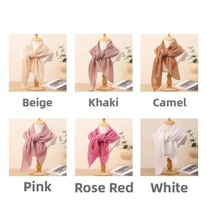 Dettaglio di foulard a pieghe colorati nei toni del beige, kaki, rosa e bianco