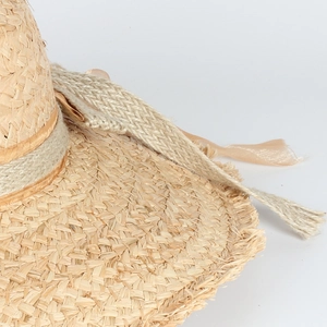 Detail of raffia straw hat with champagne silk ribbon and rustic woven rope accent