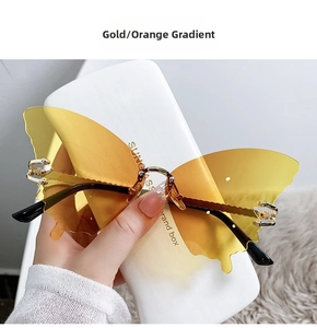 Detail of butterfly-shaped rimless sunglasses with gold temples and gradient orange lenses