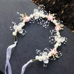 Detail von Blumenkranz mit weißen Perlen, gefrosteten Blüten und Organzaband