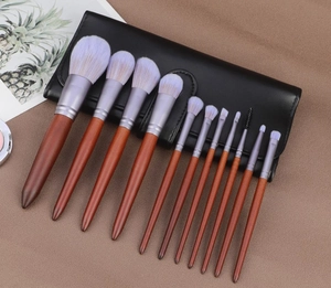 Vue de dessus de 12 pinceaux de maquillage avec manche en acajou et poils dégradés violets