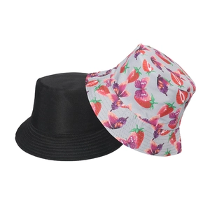 Detail view of cotton bucket hats in black and grey with red strawberry and floral prints