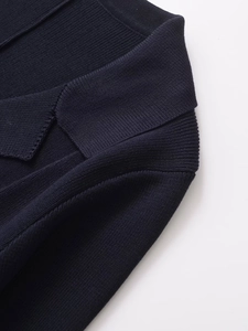 Macro shot of navy knit cardigan neckline with premium flower-shaped button detail