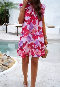 Robe fleurie élégante sans manches avec col à volants portée par un mannequin près d'une piscine