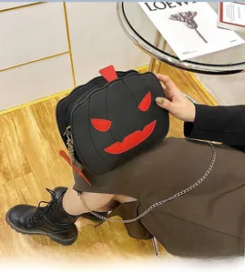 Close-up of Halloween devil pumpkin crossbody bag with red face and gold chain