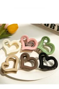 Detailed set of six colorful heart-shaped acrylic hair claws in a ceramic display