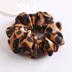 Close-up of leopard print scrunchie showing fabric texture and brown animal pattern