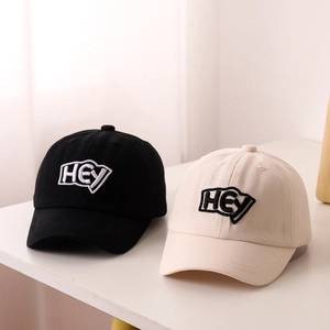 Detailed embroidery of HEY logo on cotton baseball caps for kids in black and beige