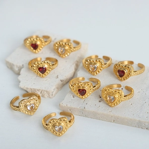Elegantes anillos de acero de titanio bañados en oro con circonitas de corazón rojas