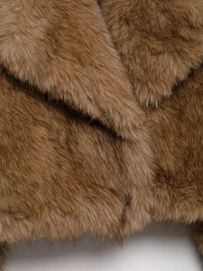 Detailed close-up showing the brown faux fur texture and wide lapel of the jacket