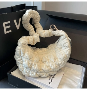 Detail of creamy white plush cloud tote bag with quilted texture and silver zipper
