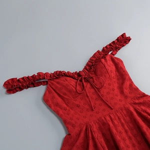 Detail of red hollow lace dress featuring elastic ruffled straps and a bow tie neckline